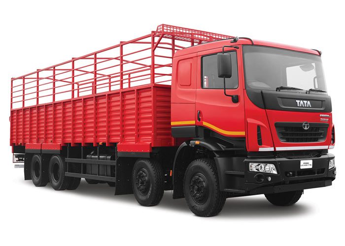 Red cargo truck with a long open-sided trailer, ready for hauling goods in front of a white background.